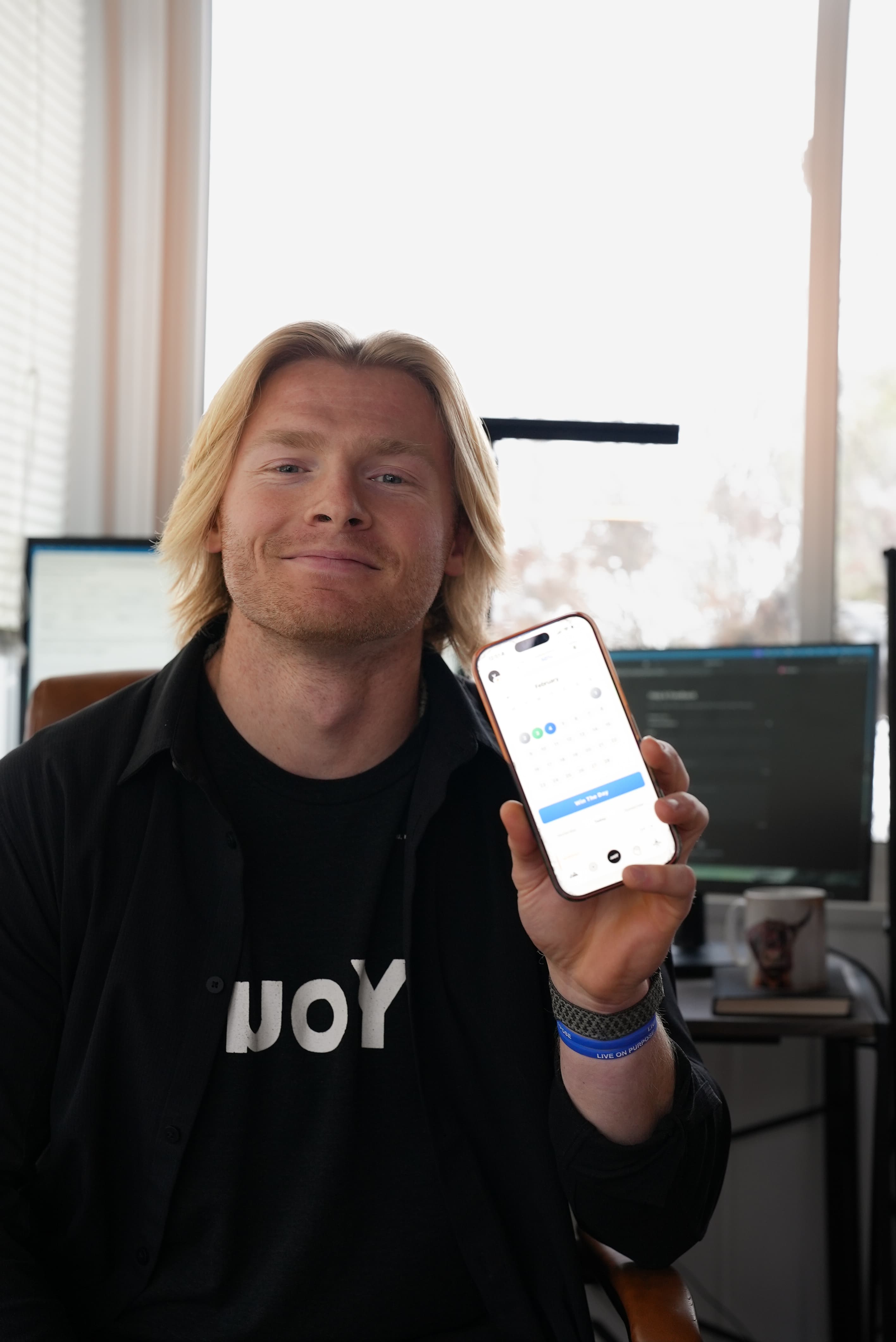 Harrison holding the YOU.PRJCT app