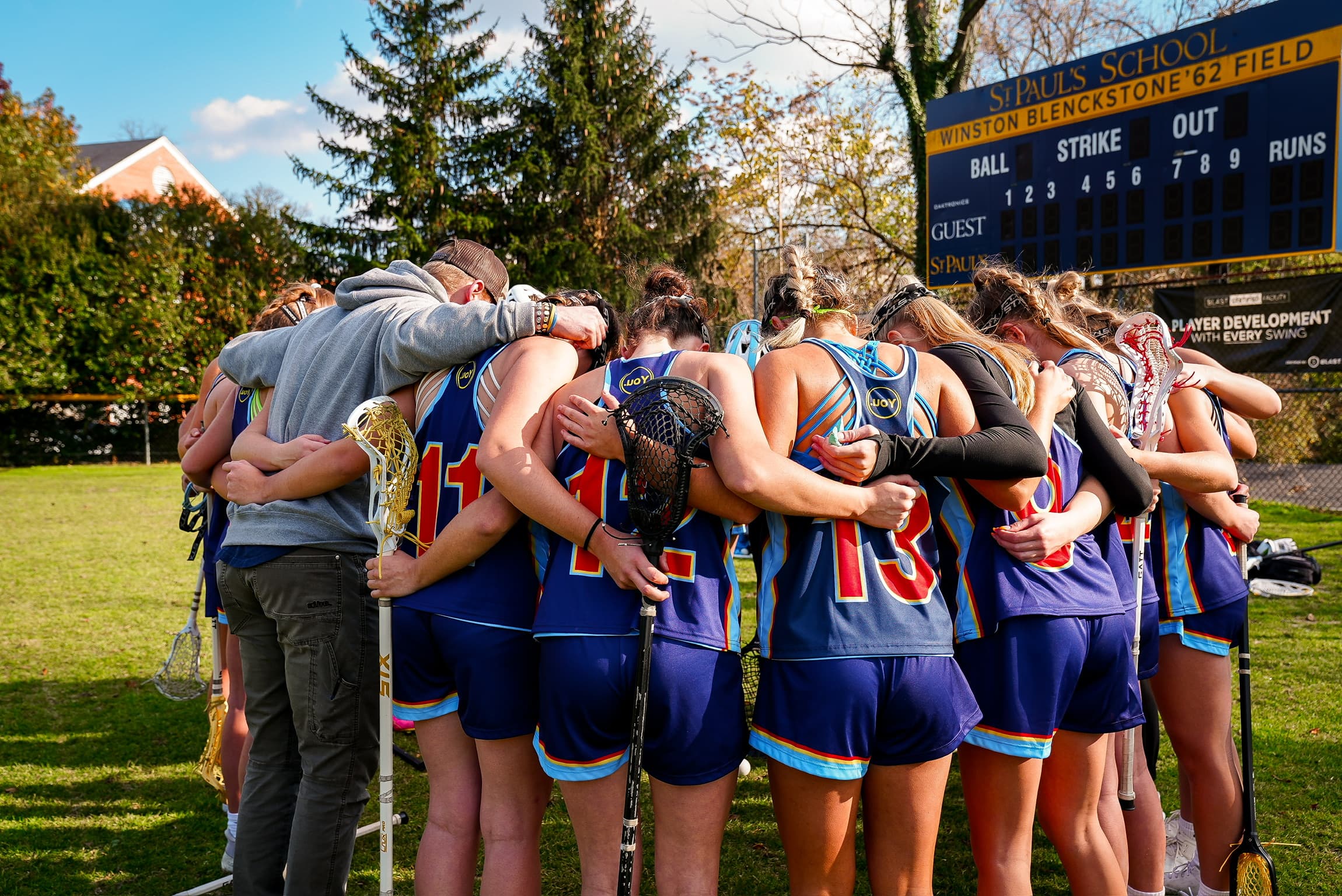 Athletes in a team huddle, arms around each other